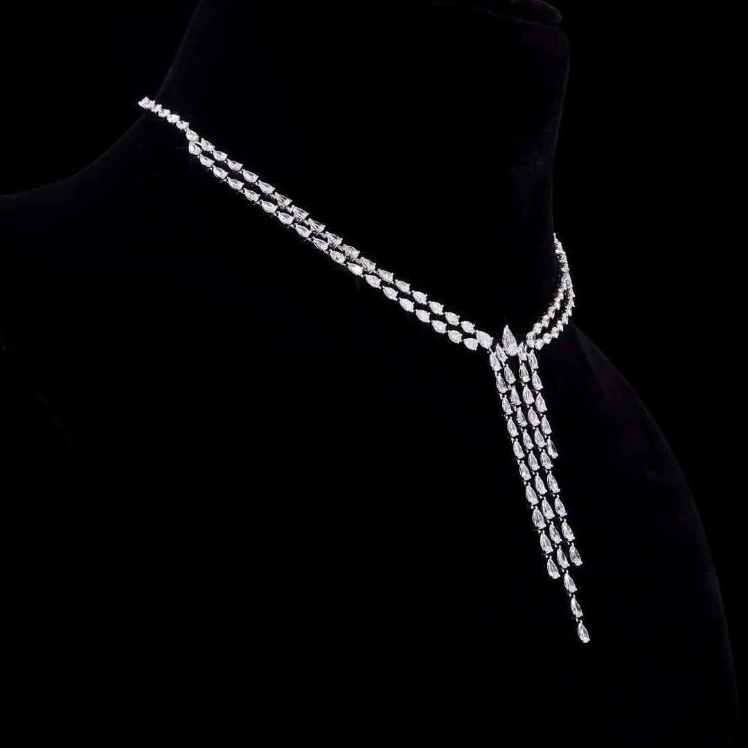 Elegant diamond necklace on a black background with a visible brand logo.